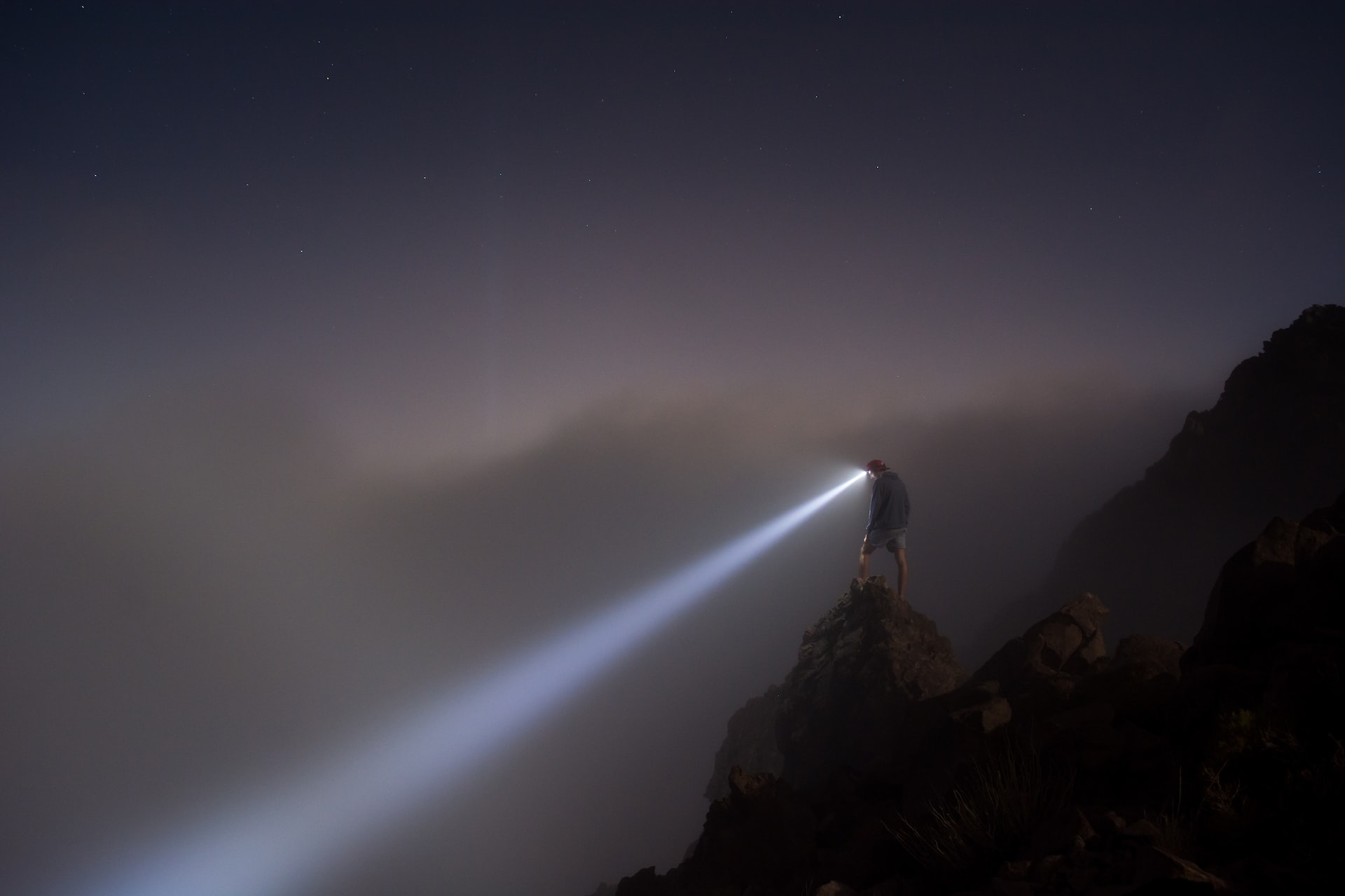 Person with headlight in darkness